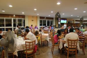 eine Gruppe von Personen, die in einem Restaurant an Tischen sitzen in der Unterkunft Hotel Arco Iris in Vilanova de Arousa