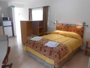 1 dormitorio con 1 cama con colcha amarilla en Montalto II en Dina Huapi