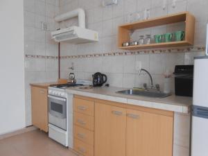 a small kitchen with a sink and a stove at Montalto II in Dina Huapi
