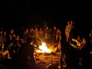 a group of people sitting around a fire at Auberge de jeunesse du Domaine à Liguori in Petite-Rivière-Saint-François