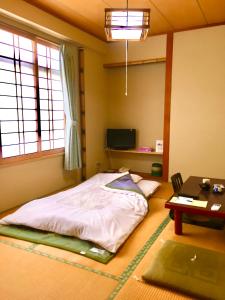 łóżko w pokoju ze stołem i oknem w obiekcie Sawaki w mieście Imabari