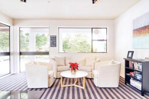 a living room with white furniture and a table at Hotel Carlton Mill in Christchurch