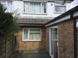 a brick house with two windows and a fence at Holiday / vacation Double Room in Greater manchester in Summerseat