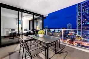 a dining room with a view of a city at night at Circle on Cavil Holidays Gold Coast in Gold Coast