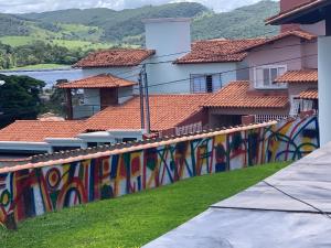 a wall with colorful graffiti on the side of a building at Chalés da Zelma in Capitólio