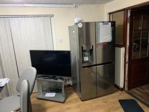 um frigorífico prateado num quarto com uma televisão em Holiday / vacation Double Room in Greater manchester em Summerseat