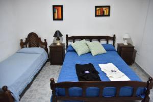 a bedroom with two beds with blue sheets and towels at El Indalo in Embalse