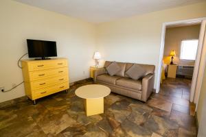 ein Wohnzimmer mit einem Sofa, einem TV und einem Tisch in der Unterkunft American Safari Motel in Wildwood Crest