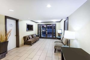 a living room with a couch and chairs and a tv at Howard Johnson by Wyndham San Diego Hotel Circle in San Diego