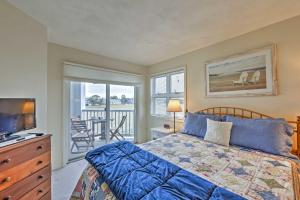 1 dormitorio con cama, TV y balcón en Breezy Oak Bluffs Condo - Steps to Inkwell Beach!, en Oak Bluffs