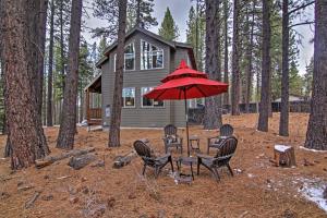 a table and chairs with a red umbrella in front of a house at Luxurious South Lake Tahoe Lodge Less Than 2 Mi to Lake! in South Lake Tahoe