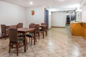 a dining room with tables and chairs and a kitchen at Super 8 by Wyndham Kingman in Kingman