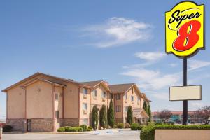 
a red brick building with a sign on the side of it at Super 8 by Wyndham Kingman in Kingman
