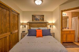 a bedroom with a bed with an orange pillow on it at Walk to Ski Slopes and Main St Cozy Breck Condo! in Breckenridge +16 photos