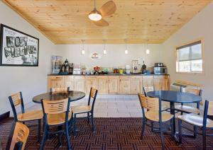 a room with two tables and chairs and a kitchen at Super 8 by Wyndham Elkins in Elkins