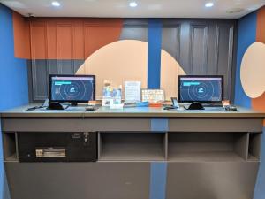 einen Schreibtisch mit zwei Computern darüber in der Unterkunft Guide Hotel Taipei Xinyi in Taipeh