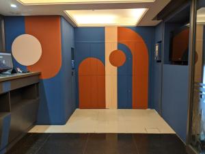 Habitación con una pared de color naranja y azul. en Guide Hotel Taipei Xinyi, en Taipéi