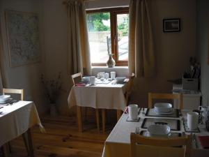 a dining room with two tables and a window at Innisfree Cottage in Eyam