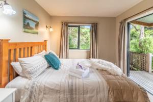 um quarto com uma cama e uma janela em Overton Cottage - Akaroa Holiday Home em Akaroa