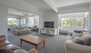 a living room with couches and a flat screen tv at Central City Gem - Napier Holiday Home in Napier