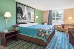 una camera d'albergo con letto e finestra di Super 8 by Wyndham Harrisburg Hershey West a Harrisburg