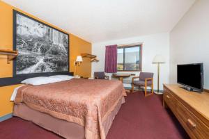 a hotel room with a bed and a flat screen tv at Super 8 by Wyndham Front Royal in Front Royal