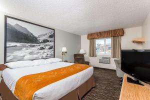 a hotel room with a bed and a flat screen tv at Super 8 by Wyndham Lewistown in Lewistown
