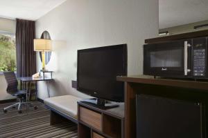 a hotel room with a flat screen tv and a living room at Super 8 by Wyndham Pocatello in Pocatello