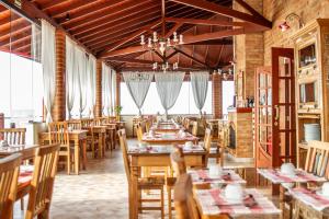 uma sala de jantar com mesas e cadeiras de madeira em Pousada Aldeia Manacás em São Bento do Sapucaí