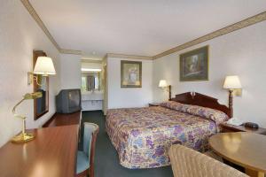 a hotel room with a bed and a table at Days Inn by Wyndham Cartersville in Cartersville