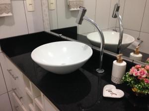 a black and white bathroom with a sink and mirror at Charmoso apto com clima de casa em Canasvieiras in Florianópolis +55 photos