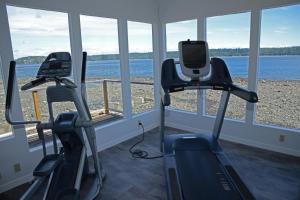 einen Fitnessraum mit zwei Laufbändern und Blick auf das Wasser in der Unterkunft Anchor Inn and Suites in Campbell River