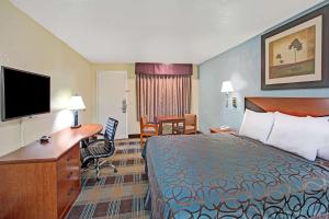 Pokój hotelowy z łóżkiem i biurkiem w obiekcie Days Inn by Wyndham Ladson Summerville Charleston w mieście Ladson