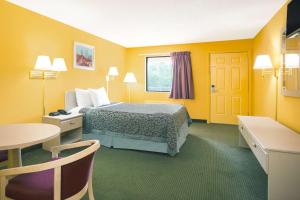a hotel room with a bed and a table at Days Inn by Wyndham Camilla in Camilla