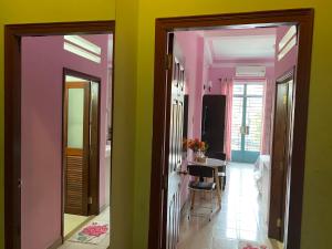un couloir avec une chambre aux murs verts et roses dans l'établissement Nhat an Homestay, à Hô-Chi-Minh-Ville