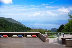 a deck with chairs and a table and a view of the water at L'Hotel de Hiei in Kyoto