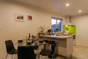 a kitchen with a table with chairs and a counter top at Central on Keiss - Blenheim Holiday Home in Blenheim