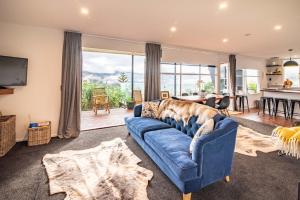 a living room with a blue couch and a table at The Grandstand - French Farm Holiday Home in French Farm