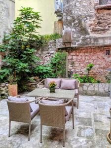 patio ze stołem i krzesłami oraz kamienną ścianą w obiekcie Private Courtyard Medieval Stone Home in Old Town w Rovinj
