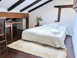 Cette chambre comprend un lit avec des draps blancs et un bureau. dans l'établissement Private Courtyard Medieval Stone Home in Old Town, à Rovinj