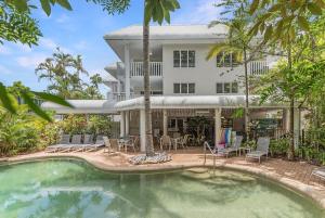 a house with a swimming pool in front of a house at Outrigger Apartments Port Douglas in Port Douglas