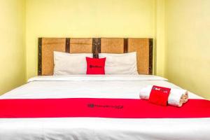 łóżko z dwoma czerwonymi poduszkami na górze w obiekcie RedDoorz @ Jalan Kapten Muslim Medan w mieście Medan