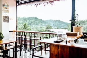a restaurant with tables and chairs and a large window at Island Brasserie Hostel in Coron
