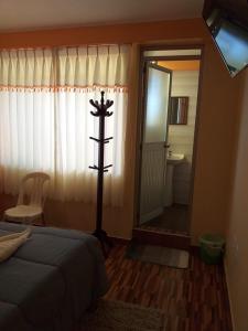 胡利亚卡Hostal Real Divina的一间带床和镜子的卧室以及一间浴室 更多3张照片