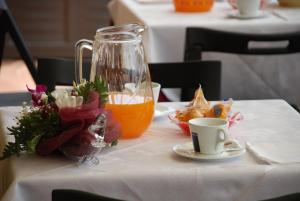 a table with a pitcher and a cup of orange juice at Hotel Vittorio Emanuele in Floridia