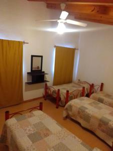 Habitación con 3 camas y ventilador de techo. en Altas Mareas 1 en Las Grutas