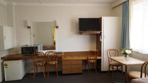 a room with a desk with chairs and a computer at Country Motor Inn in Singleton
