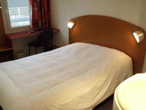 Un pat sau paturi într-o cameră la Quick Palace Auxerre