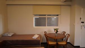 a room with a bed, table and a window at Country Motor Inn in Singleton