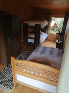 een slaapkamer met twee stapelbedden in een hut bij Cabaña Rayen in Huillinco